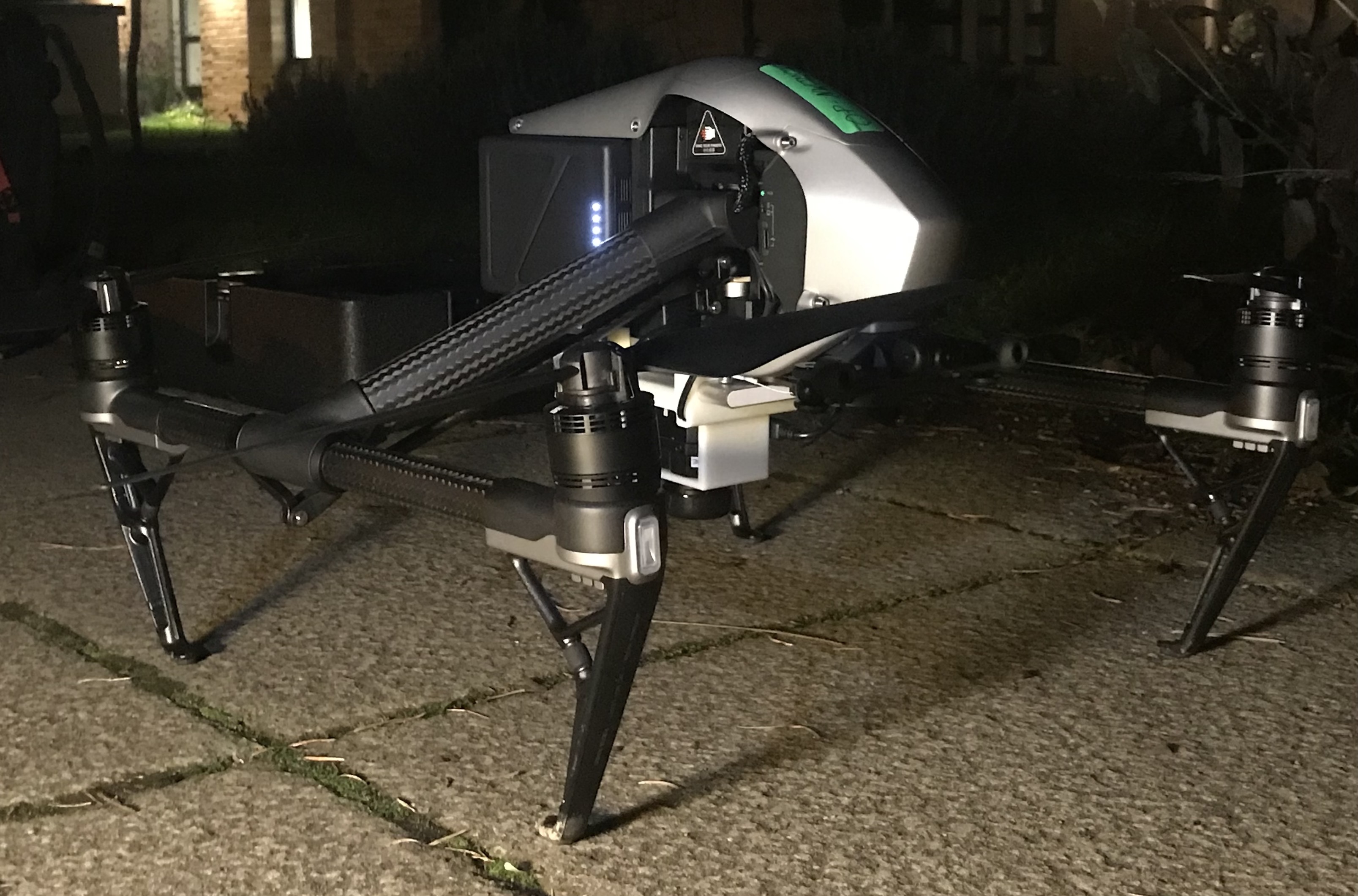 A drone soon to take flight with a thermal imaging camera attached to its underside