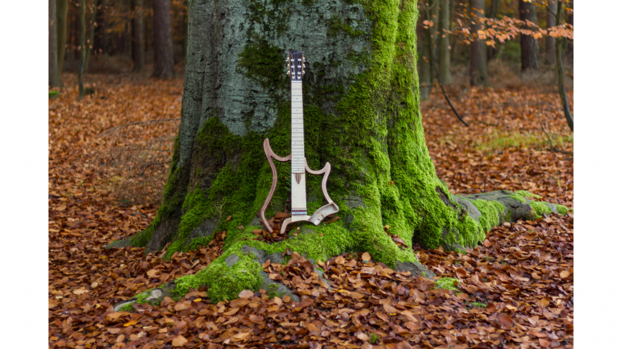 An OpenGuitar guitar resting against a tree
