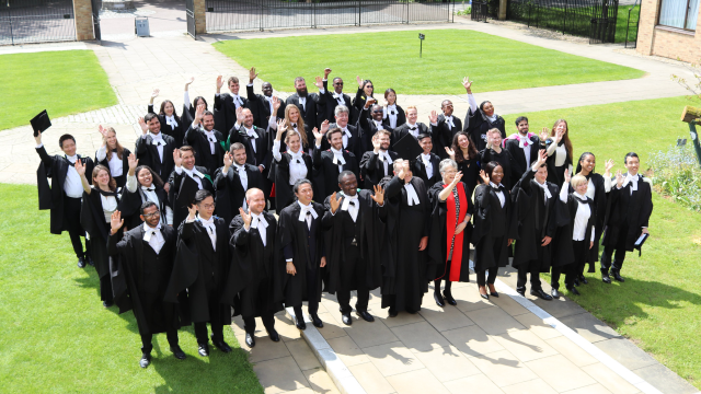A graduating cohort waves from the front court