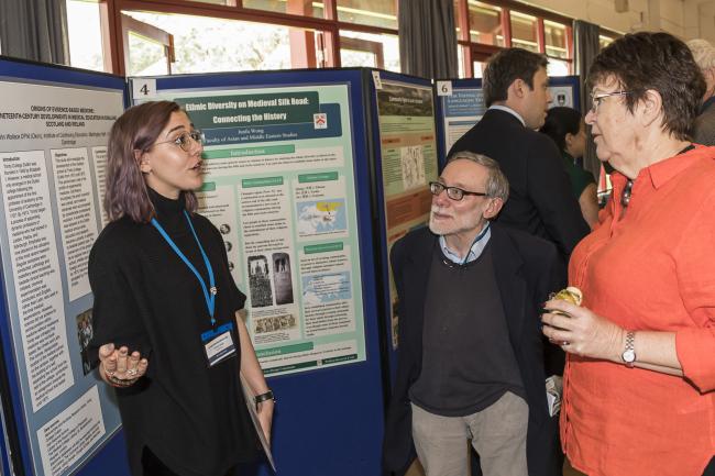 Professor Jane Clarke and Assistant Librarian DrLaurence Smith speak with a poster presenter 