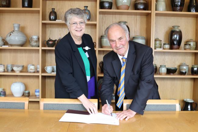 John Hughes, with Wolfson President, Professor Jane Clarke, signing his donation to the College