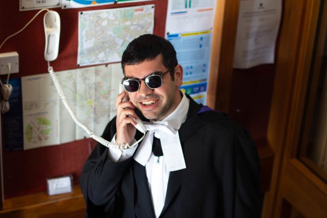 A wolfson graduand uses the phone in the porter's lodge