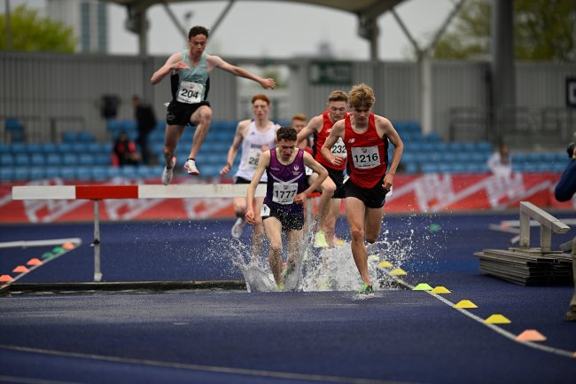 Terry (204) leaps over the hurdle in the 300m steeplechase