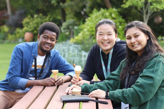Wolfson students sit outside with ice creams in the sundial garden