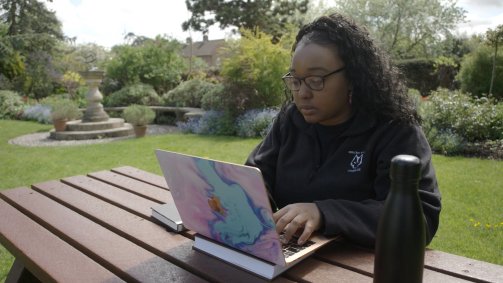 Student working on laptop outdoors