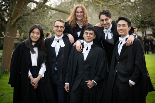 Six individuals stand together at the graduation celebrations at Wolfson College, on Saturday 23 March 2024