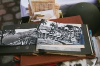 Old photograph album in the foreground; basket of old documents in the background