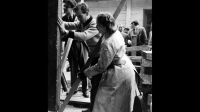 Black and white photograph of men and a woman building